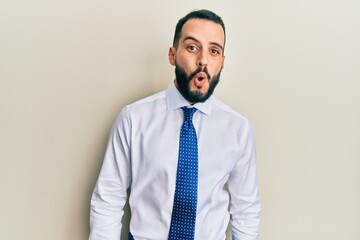 Young man with beard wearing business tie afraid and shocked with surprise expression, fear and excited face.