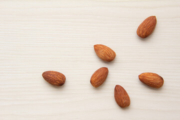 俯瞰のいくつかのアーモンドと淡い木目の背景