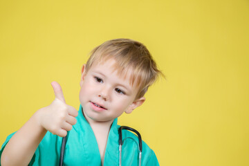 Portrait of little caucasian boy dressed in doctors showing thumb up gesture