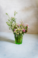 Bouquet of wild natural flowers, selective focus. Wildflowers  in vase on vintage background