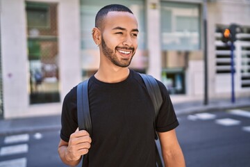 Young african american man smiling confident wearing backpack at street
