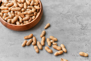 Image of bunch of peanuts in a bowl on a concrete surface