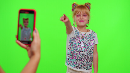 Happy funky young female blogger child kid girl, recording funny dancing video on smartphone for...