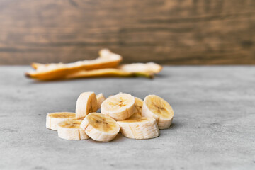Fototapeta na wymiar Photo of banana slices and peel on a concrete surface