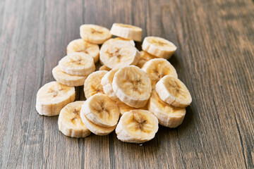 Photo of banana slices on a wooden table