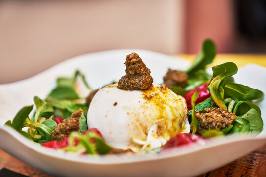 Beautiful burrata cheese with pesto on lambs lettuce salad image