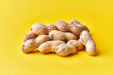  Bunch of peanuts with shell on a yellow background