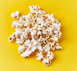  Bunch of salty popcorns on a yellow background