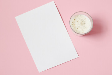 blank paper card with white candle on pastel pink background