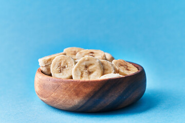  Bowl of slices of banana on a blue background
