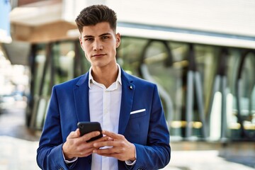 Young man using smartphone wearing suit at street
