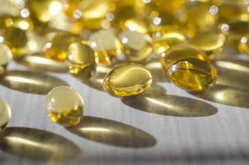 Capsules with vitamin d3 on a white wooden table, close-up