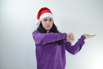 Fototapeta na wymiar Girl in red christmas hat poses in studio