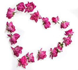 Fototapeta na wymiar Wilted rose petals shaped into heart on white