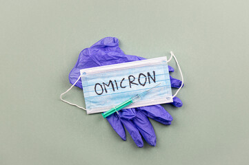 New Coronavirus Covid-19 mutation Omicron concept. Medical mask, syringe and text with letters...