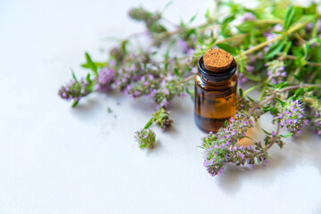 Thyme essential oil in a small bottle. Selective focus.