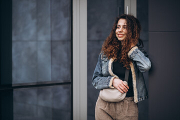 Obraz premium Young woman with curly hair in denim jacket