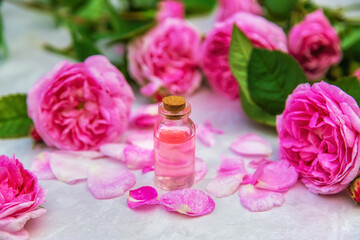 Obraz na płótnie Canvas Rose essential oil in a small bottle. Selective focus.