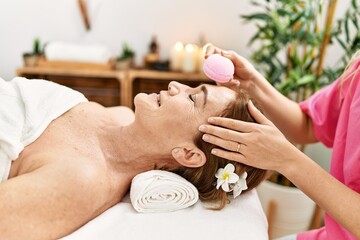 Middle age caucasian woman having facial treatment at beauty center