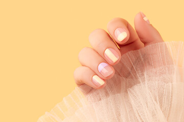Beautiful females hand with manicure on yellow background. Trendy minimal spring summer nail design - obrazy, fototapety, plakaty