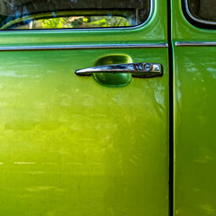 shiny olive green car door and chrome handle, space for your text