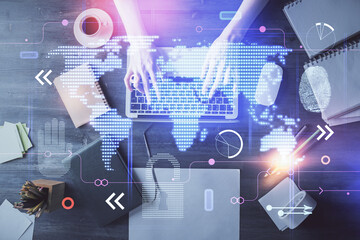 Double exposure of woman hands working on computer and world map hologram drawing. Top View. International business concept.