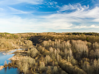 Aerial view of lake coast overgrown with sedge and dry grass. Warm spring day.