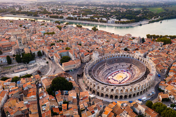 Aerial view of Arles townscape on bank of Rhone river overlooking restored antique Roman...