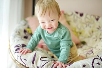 Fototapeta premium Adorable baby boy sitting in a chair by the window.
