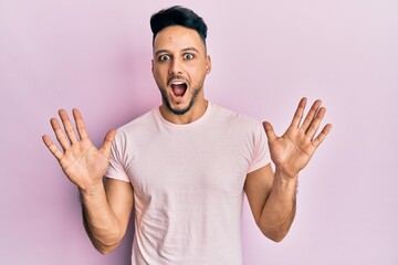 Fototapeta premium Young arab man wearing casual clothes celebrating crazy and amazed for success with arms raised and open eyes screaming excited. winner concept