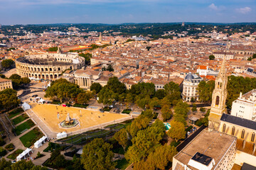 Aerial view of Roman amphitheatre on background with cityscape of Nimes. France