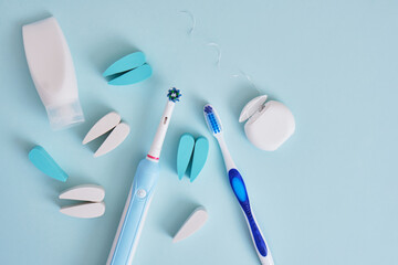 dental floss, electric and plastic toothbrushes on a blue background, which brushes are more...