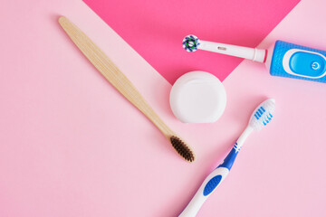 dental floss, electric, bamboo and plastic toothbrushes on pink background, which brushes more efficient or eco friendly