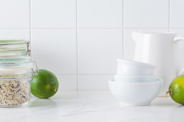 White kitchen table and tile wall with ingredients for healthy cooking.