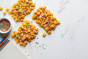 Children corn stars cereal bars with colored sprinkles and white chocolate on a white background.