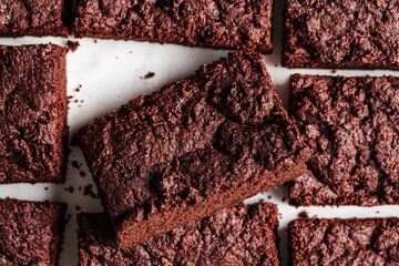 Vegan brownie squares on a white table.
