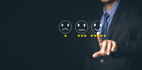 Customer Service and Satisfaction Concept Businessmen touch the virtual screen on happy smiley icons to achieve service satisfaction and feedback with excellent rated reviews.