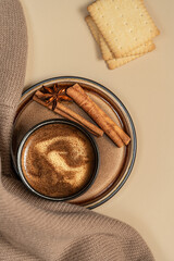 Cup of coffee with cookie,cinnamon and star anis. Warm sweater. Cozy autumn background.Copy space. Composition in beige colors.
