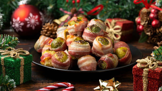 Christmas Streaky Bacon Wrapped Brussel Sprouts With Decoration, Gifts, Green Tree Branch On Wooden Rustic Table