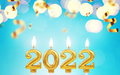 Gold candles 2022 burning on a blue background with confetti and bokeh lights. New Year's Eve 2022 card
