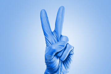 Hand in blue glove. Two fingers sign. Victory sign isolated. Peace symbol hand.