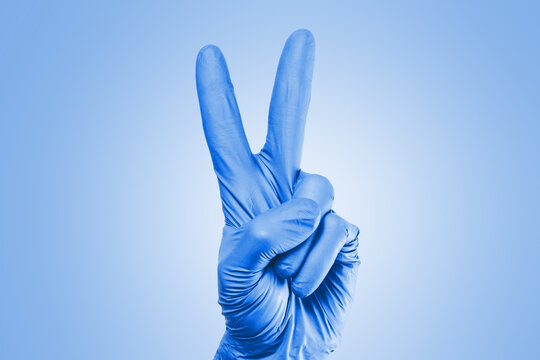 Hand in blue glove. Two fingers sign. Victory sign isolated. Peace symbol hand.
