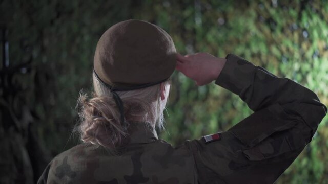 In the temporary barracks, the lady soldier salutes. Discipline and order.