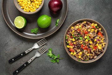 Salad with black beans, corn and quinoa in a bowl on a dark grunge background. Mexican food. Top view, flat lay. Selective focus
