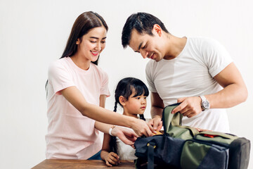 Happy asian family father and mother with daughter packing school bag with books before going to school at home.back to school