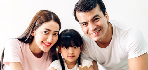 Portrait enjoy happy smiling love asian family father and mother with young parents little child asian girl daughter play in moments good time sit on wall background at home