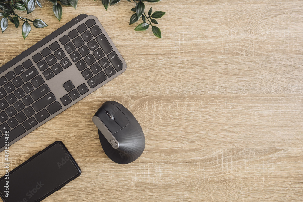 Poster top view of home desk table with keyboard, ergonomic mouse and accessory on table.