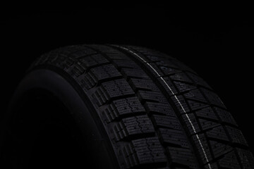 parts of a black winter tire on a black background, shot with depth of field