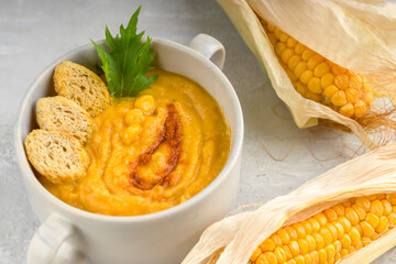 Delicious hot creamy corn soup on a light background. Food for vegans and vegetarians. Healthy diet. Top view.