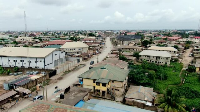 Mowe Town in Nigeria's Ogun State - view of a dirt road and a thriving West African city - ascending aerial view